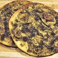 two flat pieces of bread with a dark green spice on top
