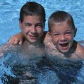two kids in a pool swim