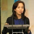 Fei-Fei Li speaking at a podium